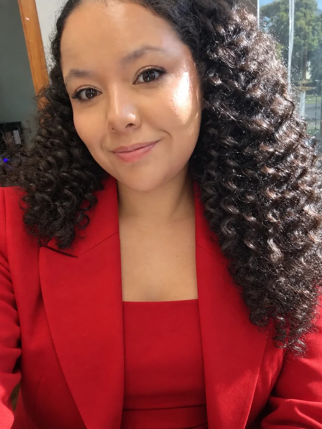 Ritieli Hermes sorrindo, de blazer vermelho